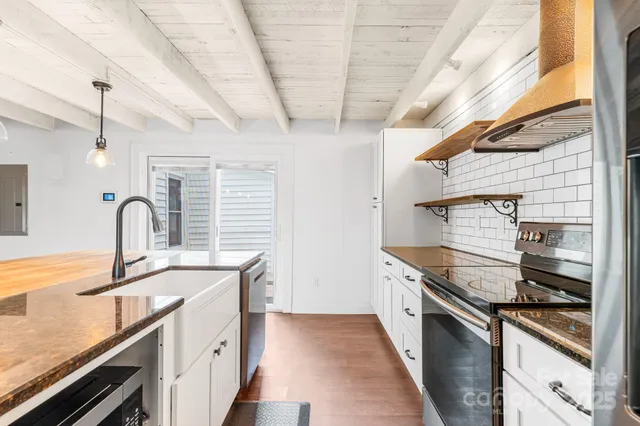 a kitchen with stainless steel appliances granite countertop a sink and a stove