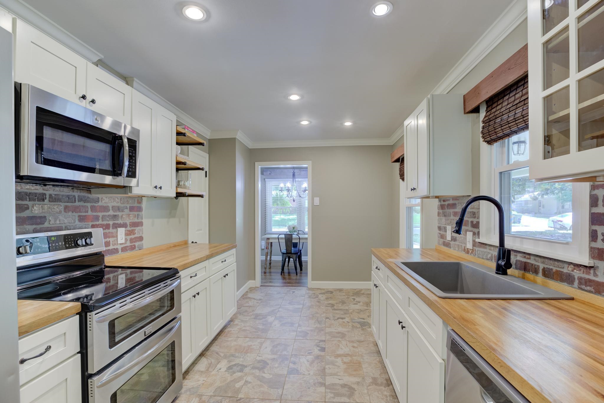 1427 Wilbec Road Memphis, TN 38117 - Photo 8 of 25 a kitchen with stainless steel appliances granite countertop a sink and a stove top oven with wooden floor
