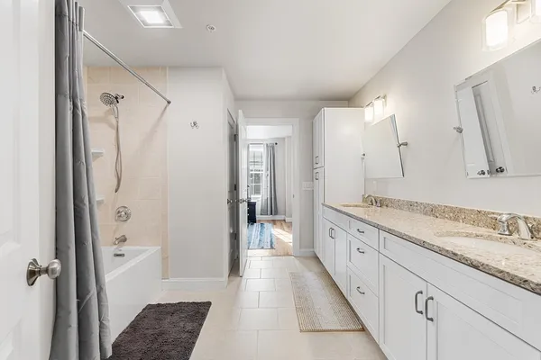 a spacious bathroom with a granite countertop sink mirror and a shower