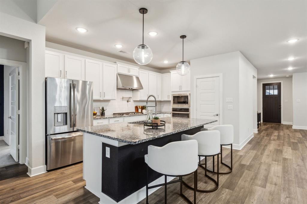 2417 Robin Way Northlake, TX 76247 - Photo 6 of 27 a kitchen with stainless steel appliances granite countertop a sink a stove a refrigerator cabinets and chairs