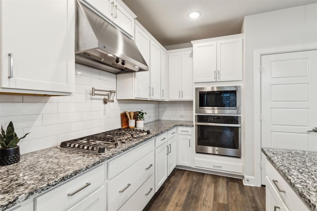 2417 Robin Way Northlake, TX 76247 - Photo 7 of 27 a kitchen with stainless steel appliances granite countertop a sink stove and cabinets