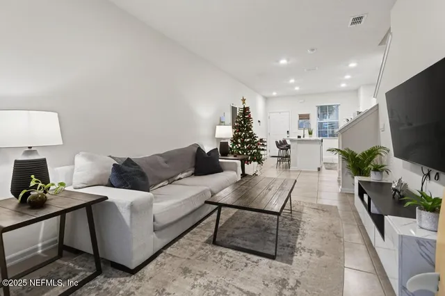 a living room with furniture a flat screen tv and a potted plant