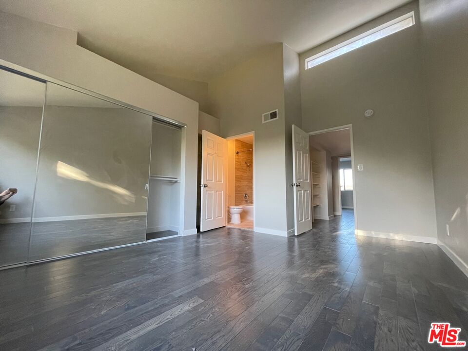 7327 Willoughby Avenue, Unit 6 Los Angeles, CA 90046 - Photo 4 of 24 a view of an empty room with wooden floor and a window