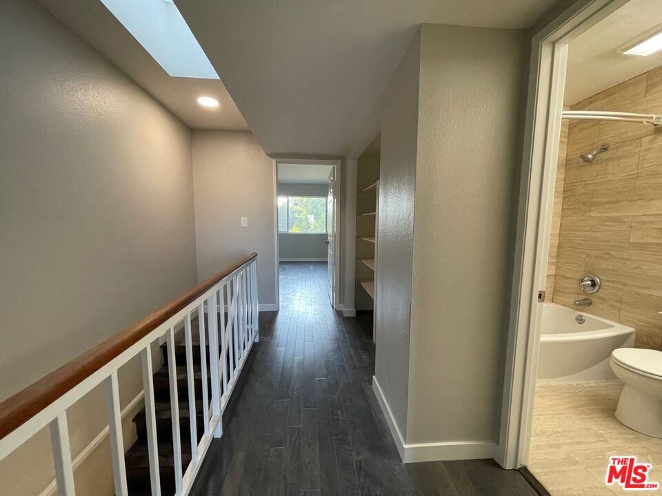 7327 Willoughby Avenue, Unit 6 Los Angeles, CA 90046 - Photo 10 of 24 a view of a hallway with wooden floor and a bathroom