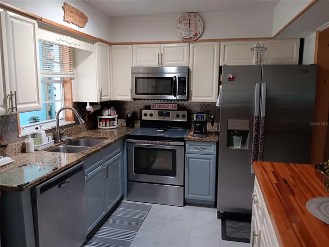 a kitchen with stainless steel appliances a stove a sink and a refrigerator