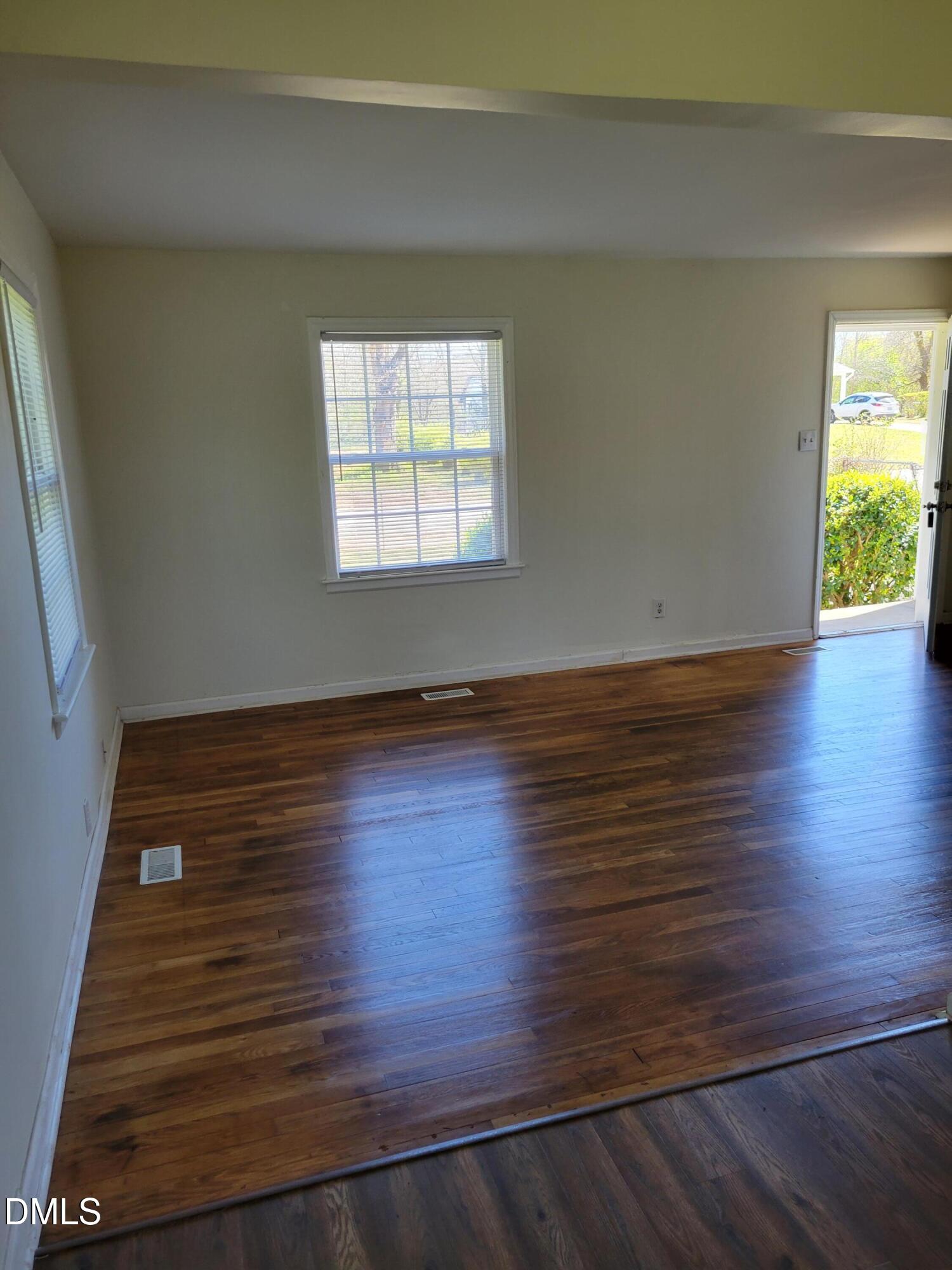 1145 Brighton Road Raleigh, NC 27610 - Photo 4 of 10 a view of an empty room with wooden floor and a window