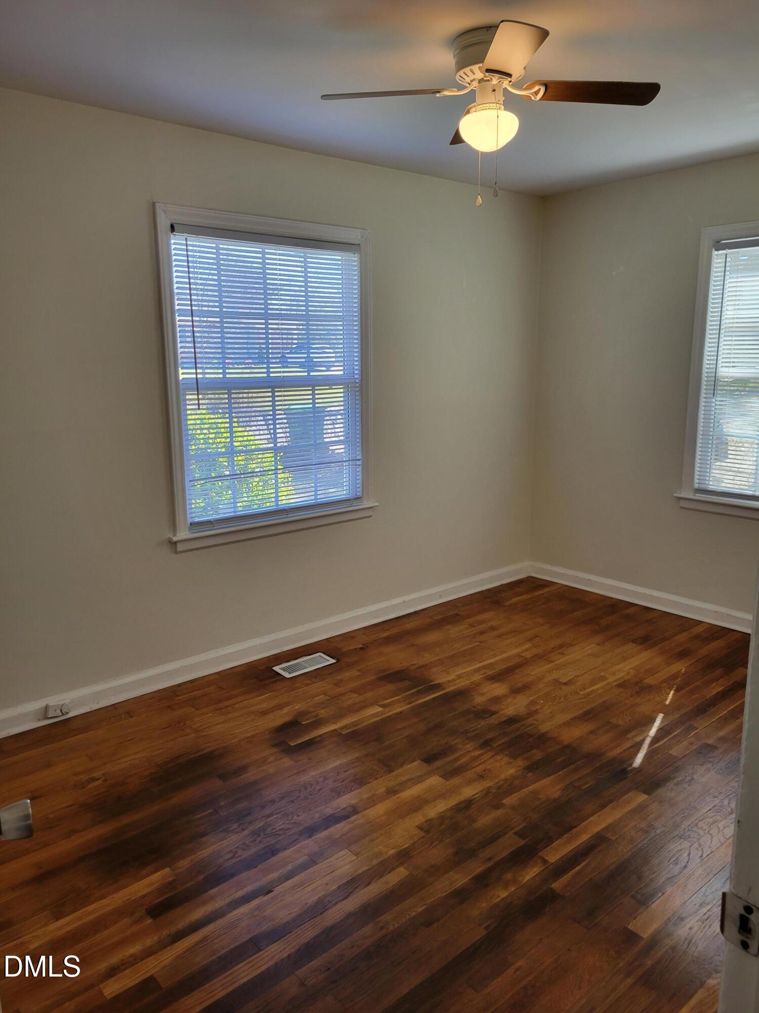 1145 Brighton Road Raleigh, NC 27610 - Photo 7 of 10 a view of an empty room with wooden floor and a window