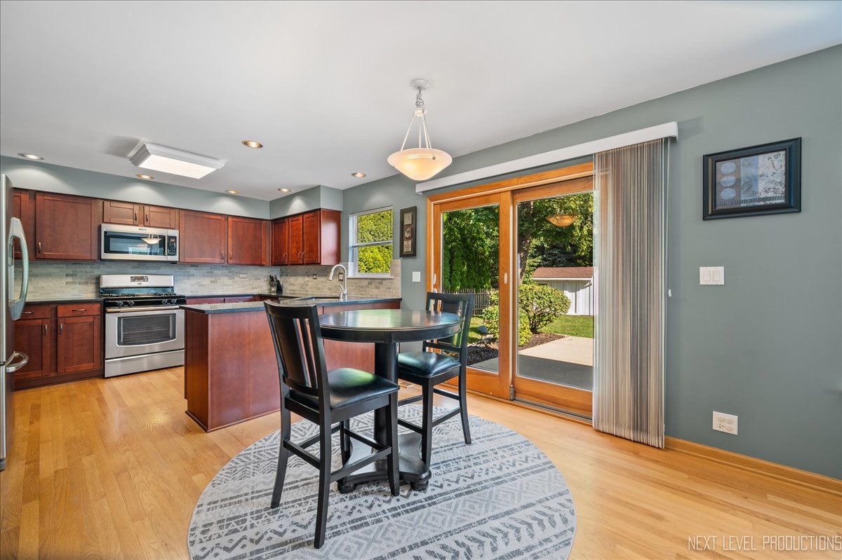 1244 Churchill Road Bartlett, IL 60103 - Photo 12 of 33 a kitchen with stainless steel appliances granite countertop a stove a refrigerator a oven a sink with a dining table and chairs