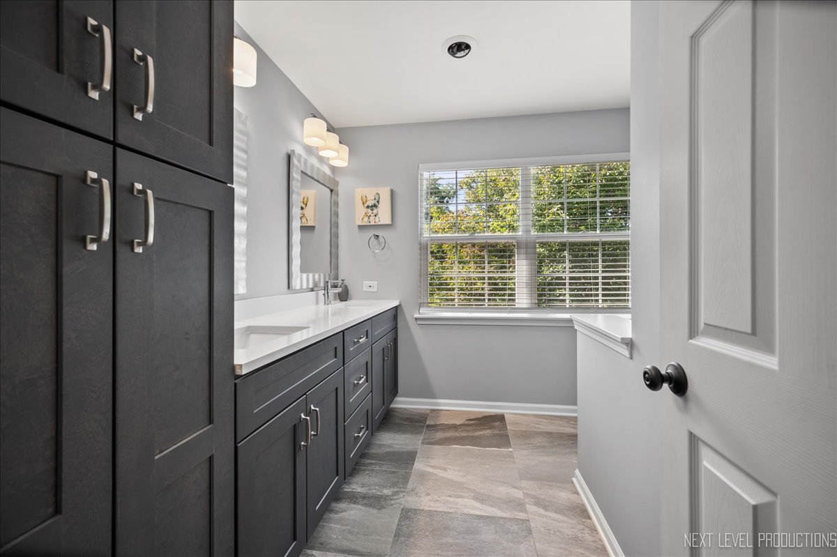 1244 Churchill Road Bartlett, IL 60103 - Photo 17 of 33 a bathroom with a tub sink and mirror