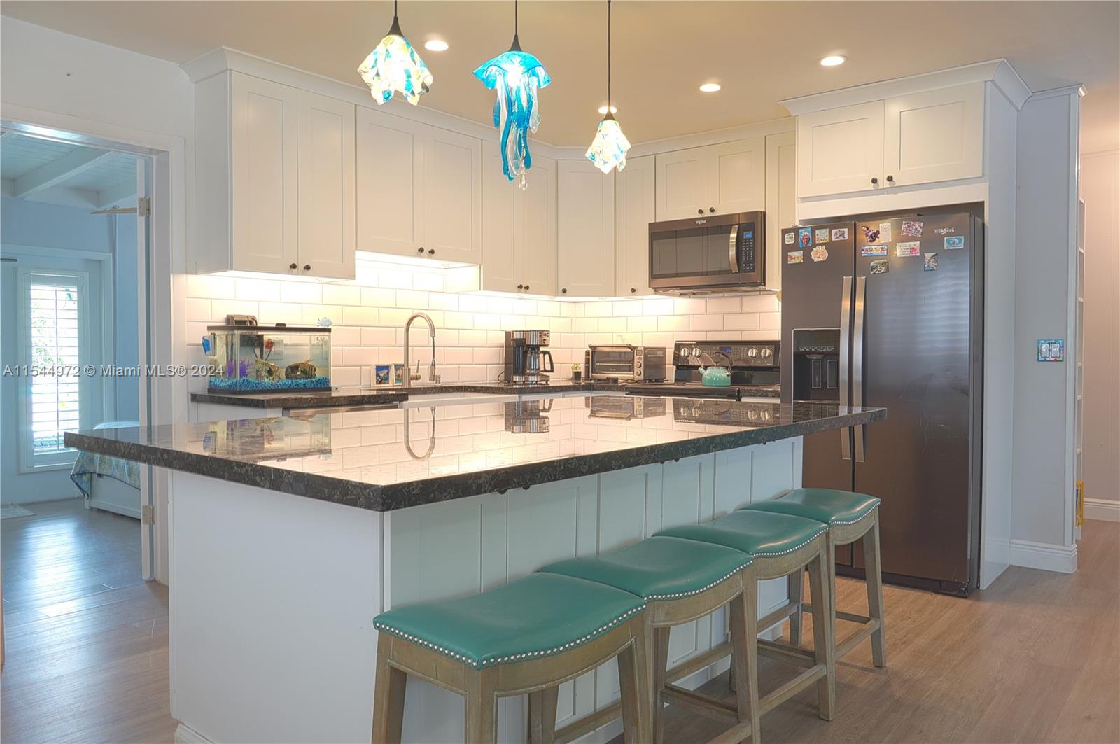 a kitchen with kitchen island granite countertop a sink and refrigerator