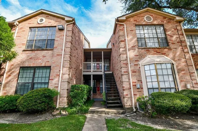 front view of a brick house with a clock on the wall