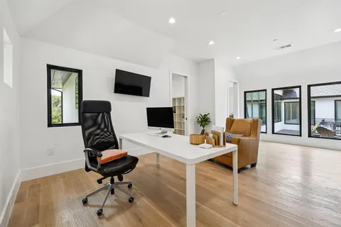 a view of a workspace with furniture and a flat screen tv