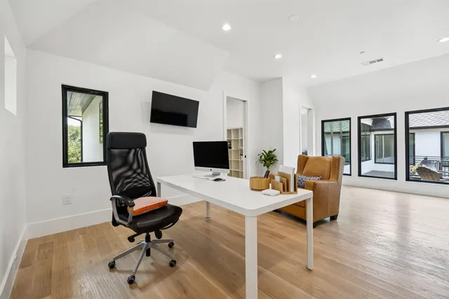 a view of a workspace with furniture and a flat screen tv