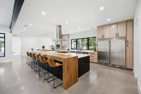 a dining hall with stainless steel appliances granite countertop a stove and a refrigerator