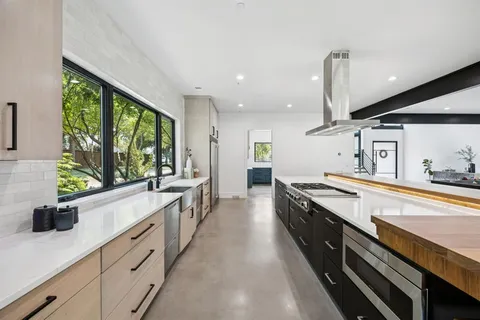a large kitchen with stainless steel appliances lots of counter space and a sink