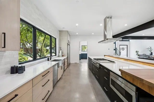 a large kitchen with stainless steel appliances lots of counter space and a sink