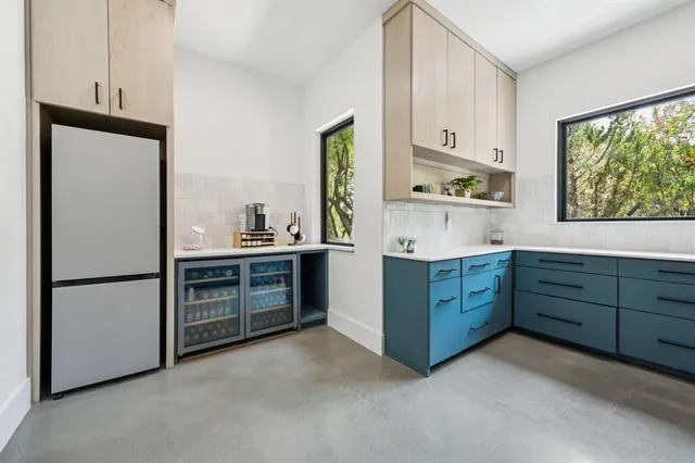 a kitchen with stainless steel appliances a stove a refrigerator and a window