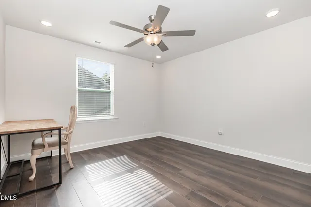 an empty room with a window and a ceiling fan