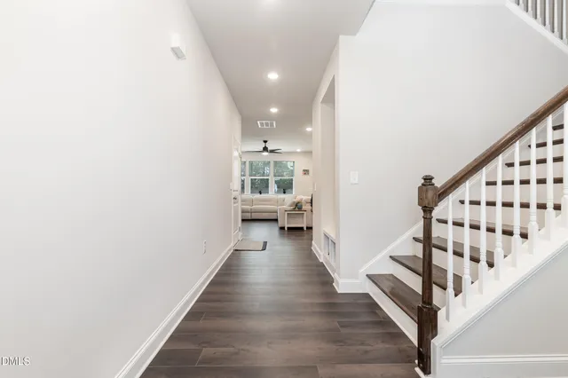 a view of a hallway with wooden floor and staircase