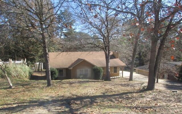a front view of a house with a yard and large tree