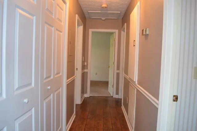 a view of a hallway with wooden floor and a glass door