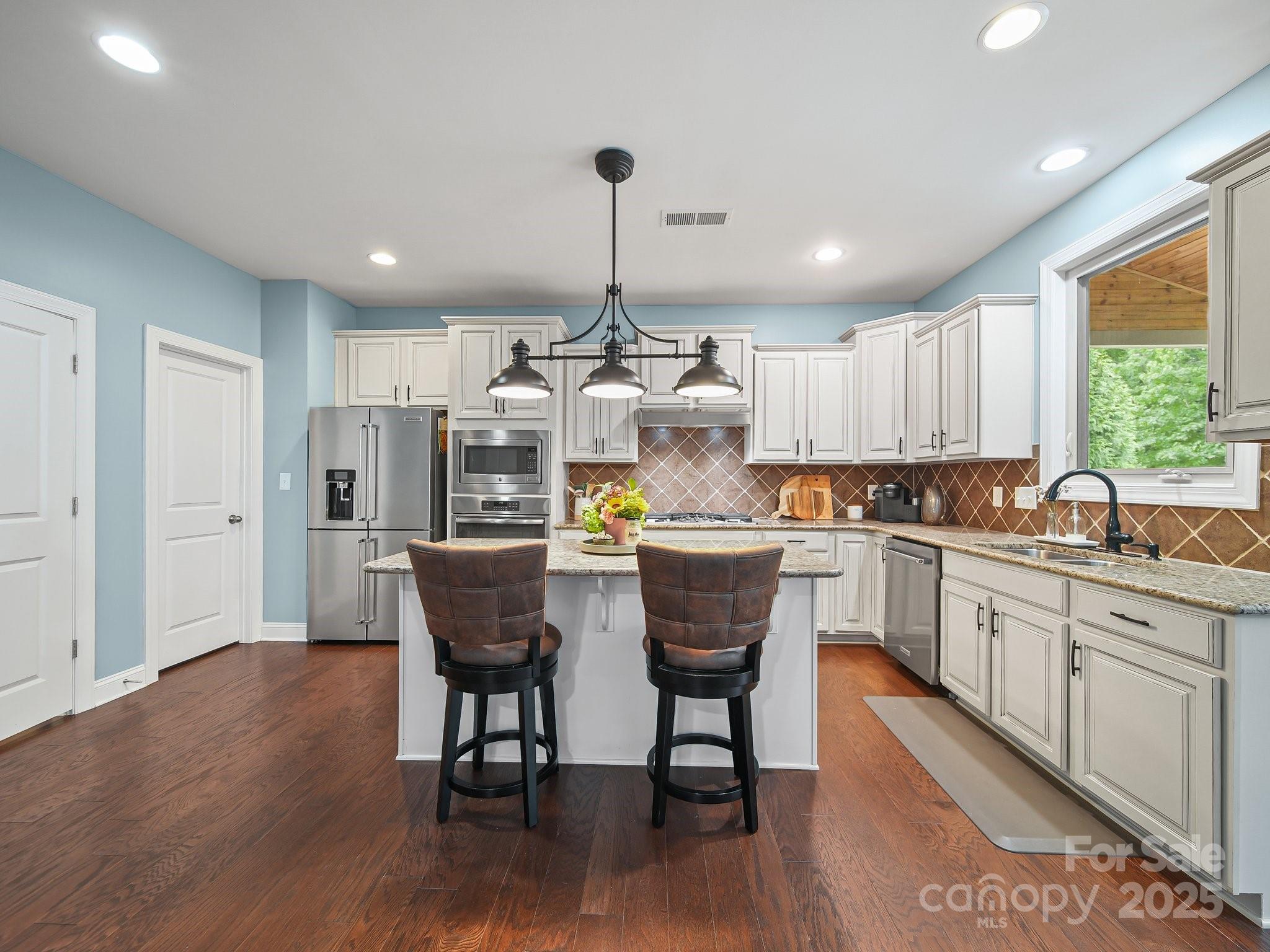 9639 Estridge Lane Concord, NC 28027 - Photo 17 of 48 a kitchen with stainless steel appliances granite countertop a white cabinets and wooden floor