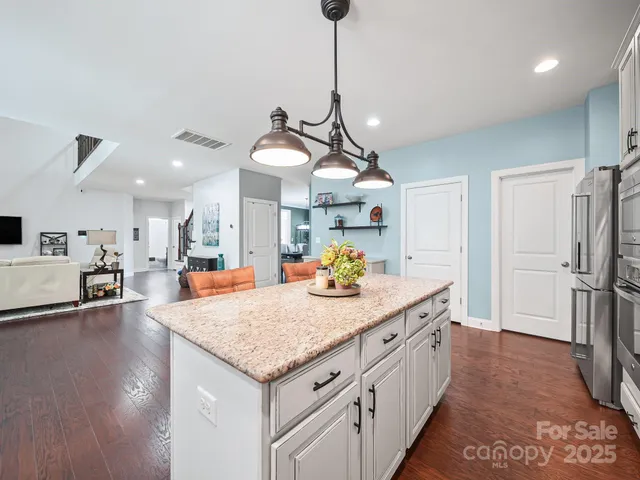 a kitchen with stainless steel appliances granite countertop a sink a refrigerator and a stove
