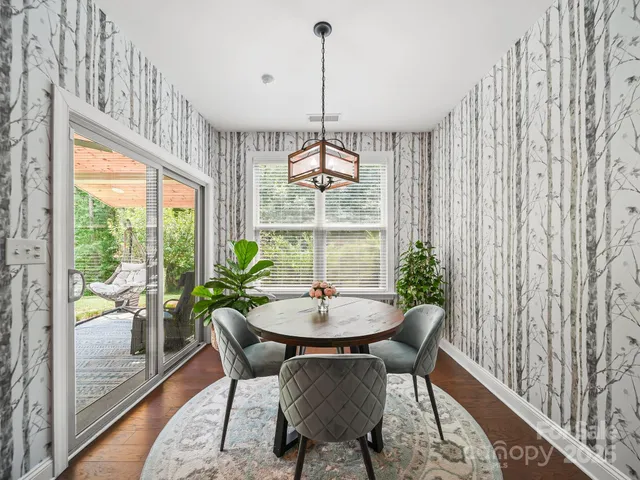 a dining room with furniture a chandelier and wooden floor