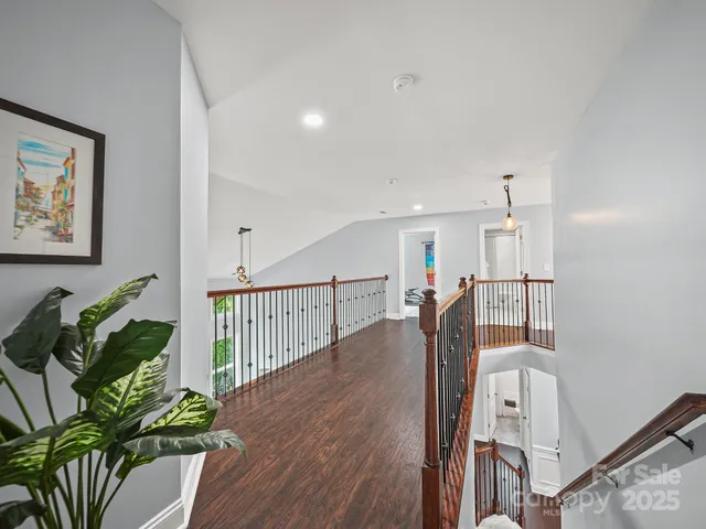 a hallway with wooden floor and windows