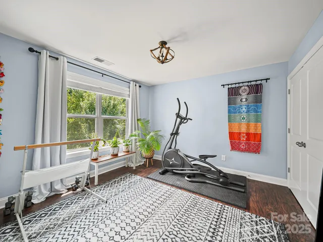 a living room with furniture gym equipment and a window