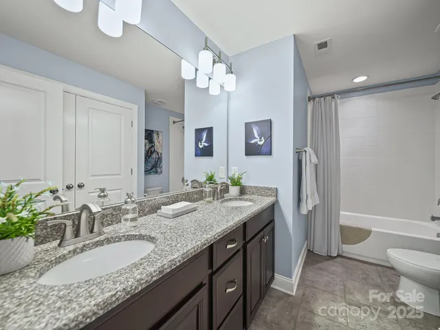 a bathroom with a granite countertop sink a toilet and a large mirror