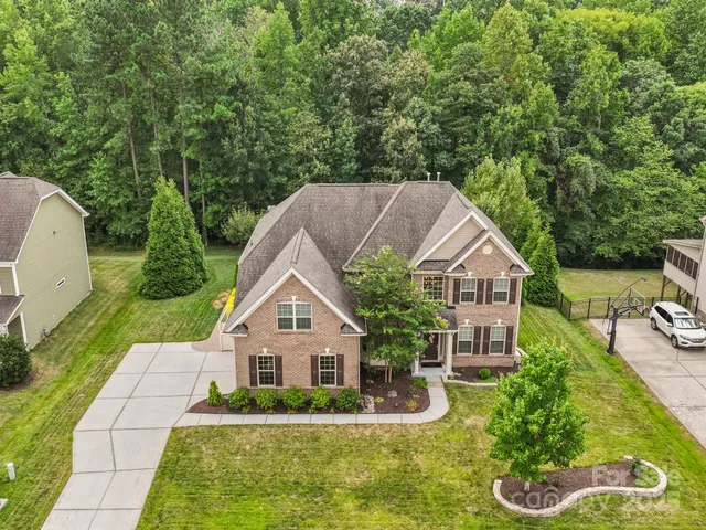 a aerial view of a house with swimming pool next to a yard