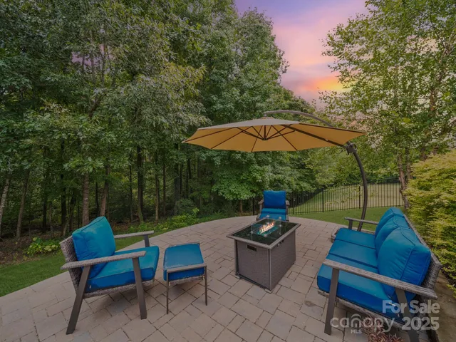 an outdoor sitting area with furniture and umbrella