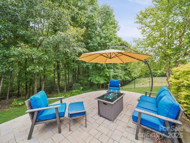 an outdoor sitting area with furniture and umbrella
