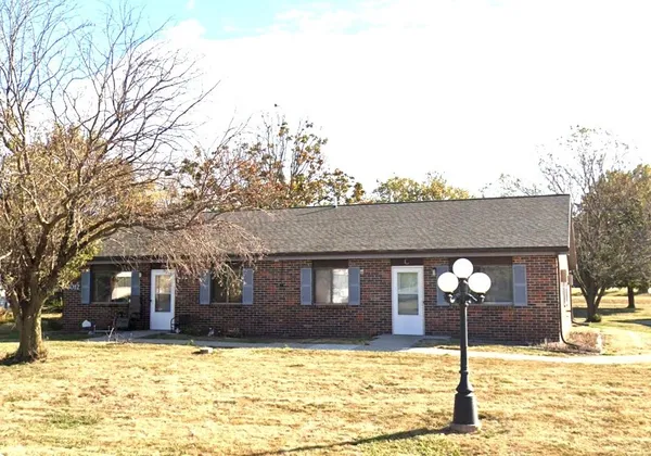 a brick house with a large tree in front of it