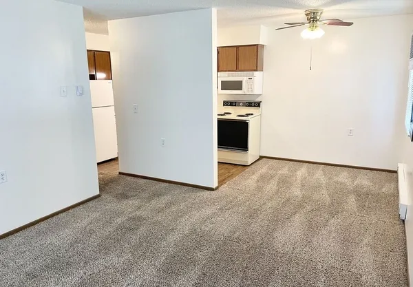 an empty room with a kitchen and a stove top oven