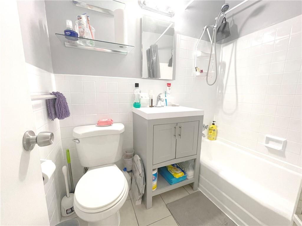 2940 West 5th Street, Unit 14C Brooklyn, NY 11224 - Photo 16 of 26 a white toilet sitting next to a bathroom sink and tub