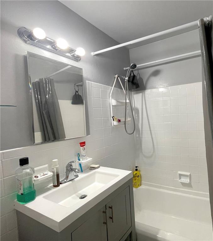 2940 West 5th Street, Unit 14C Brooklyn, NY 11224 - Photo 17 of 26 a bathroom with a sink vanity mirror and shower