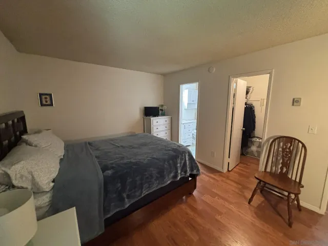 a bedroom with a bed chair and a dresser
