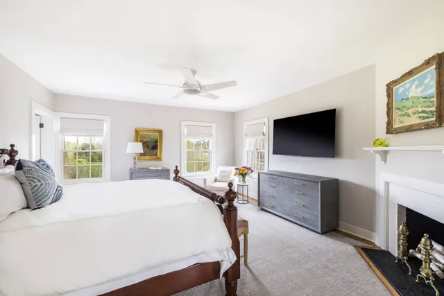a bedroom with a bed couch and a flat tv screen