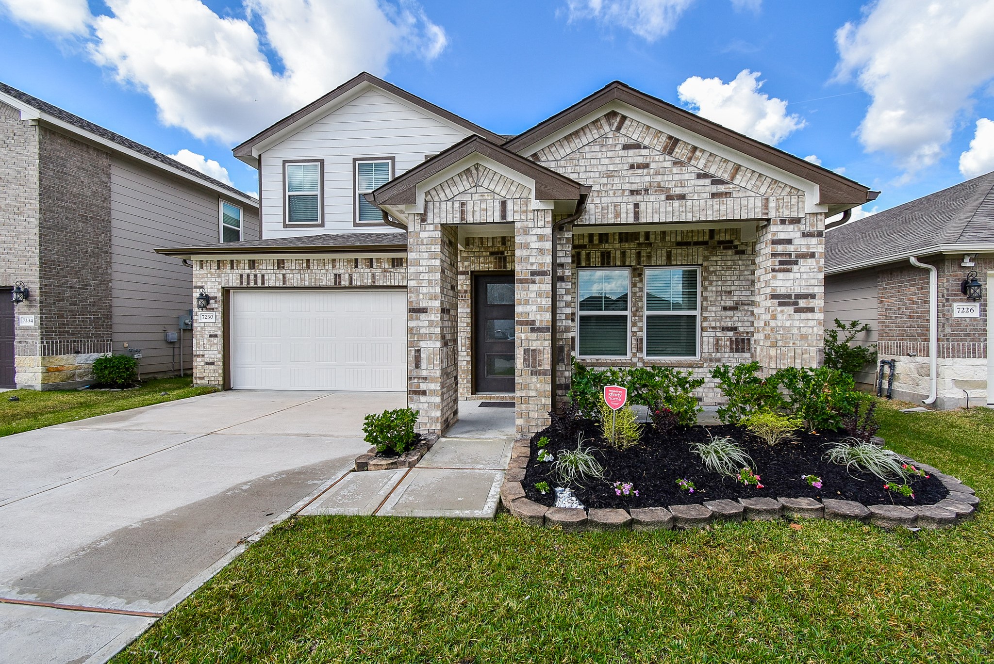 a front view of a house with a garden and plants
