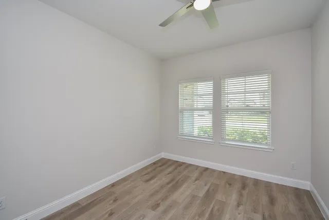 an empty room with a window and a fan