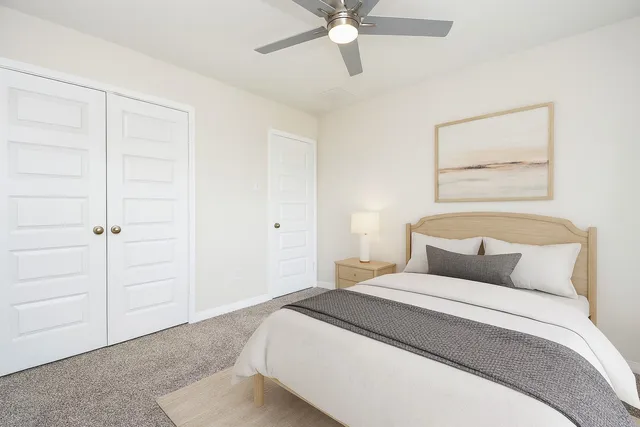 a bedroom with a bed and a ceiling fan