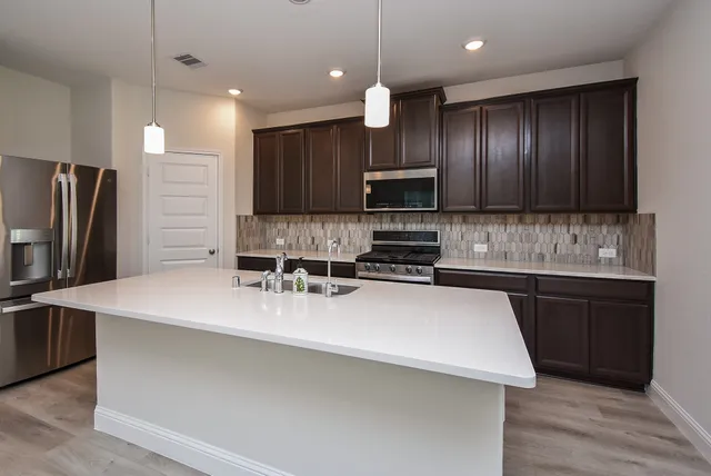 a kitchen with kitchen island a sink stainless steel appliances and cabinets