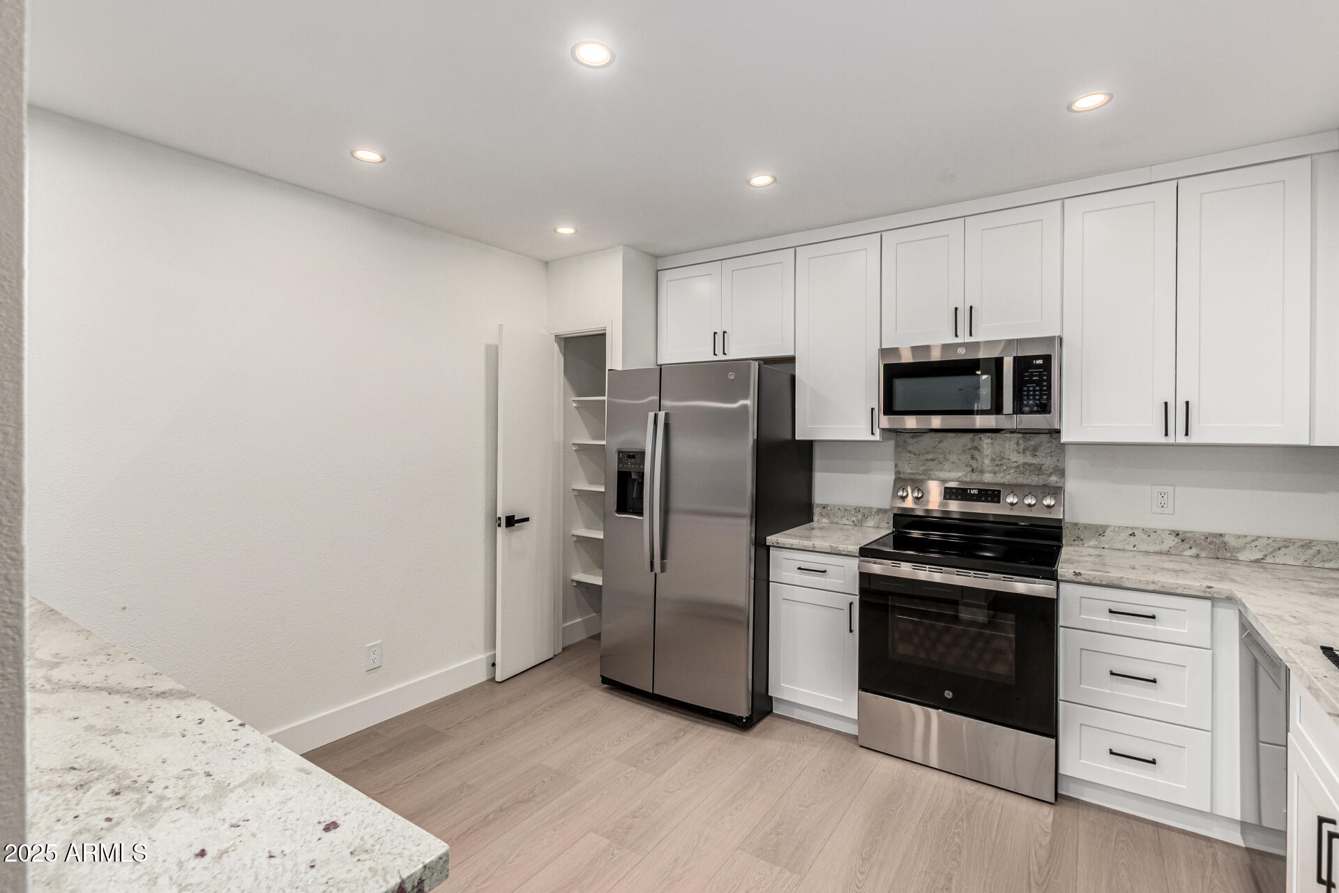 a kitchen with stainless steel appliances a refrigerator stove and microwave