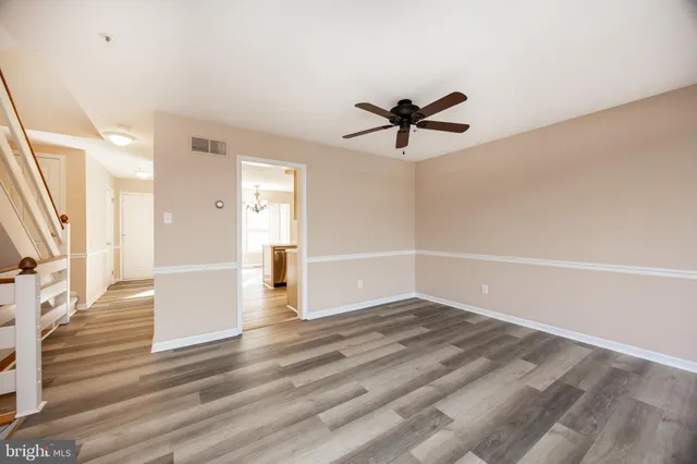 a view of a room with wooden floor and ceiling fan