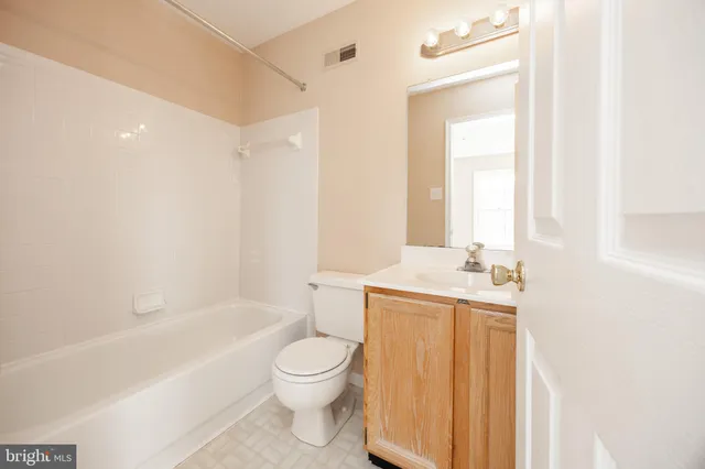 a bathroom with a toilet a sink a bath tub and a mirror