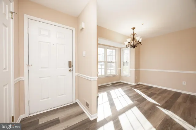 an empty room with wooden floor cabinet and windows