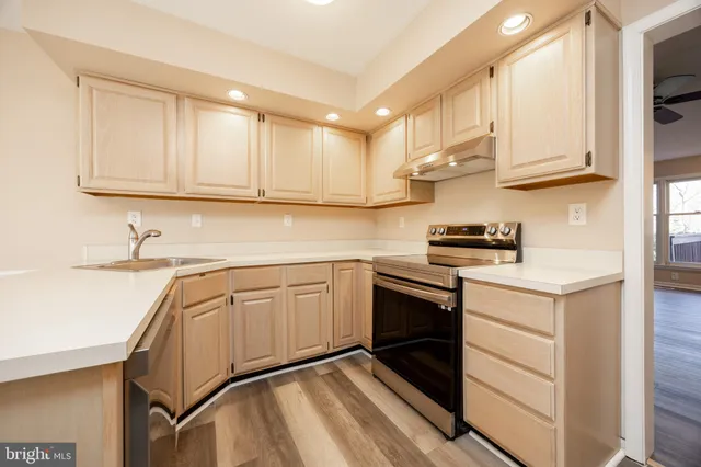 a kitchen with stainless steel appliances granite countertop a sink stove and cabinets