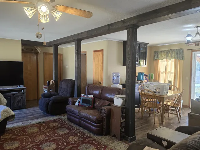 a view of a dining room with furniture a chandelier and wooden floor